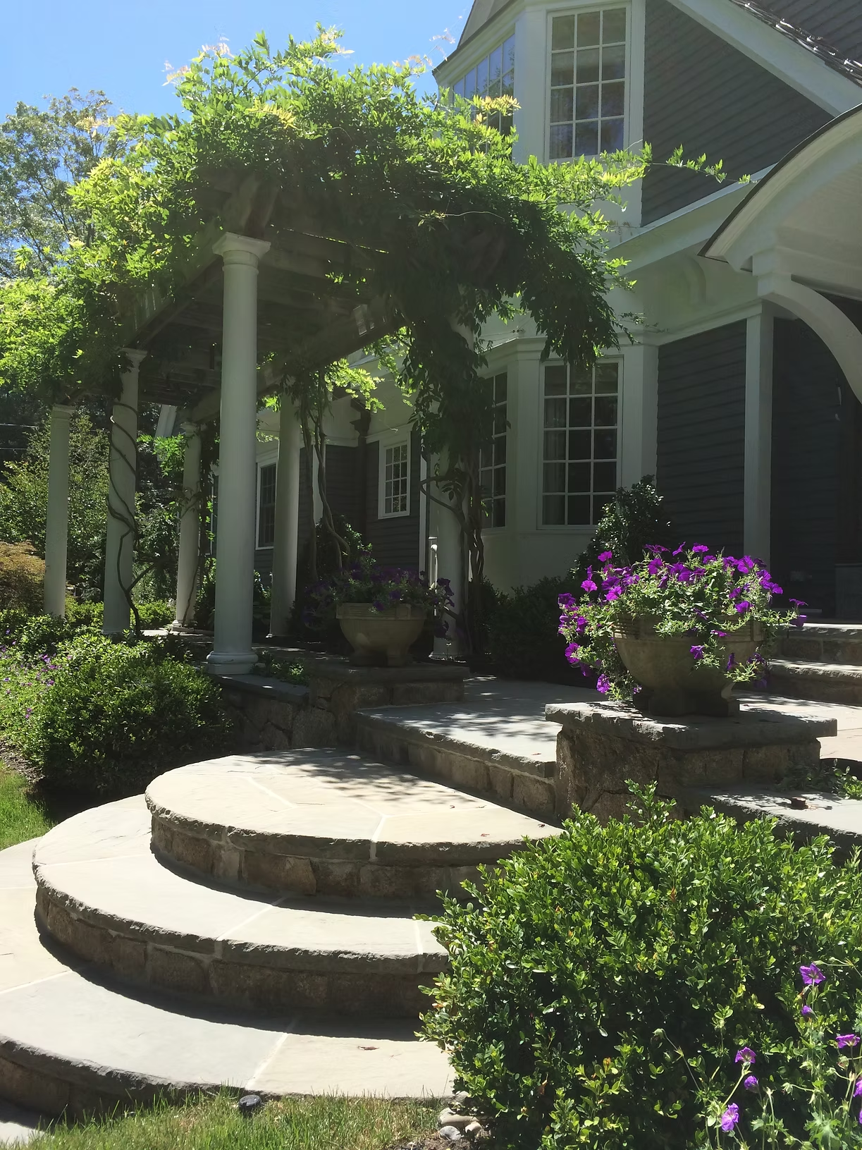 Belmont front entry stone steps with planting and seasonal containers