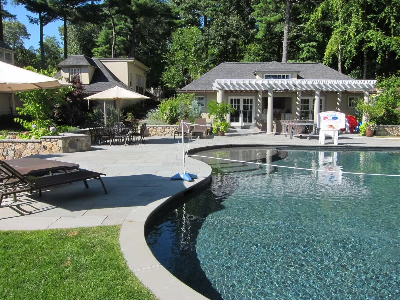 Belmont pool house patio with stonework and outdoor dining area